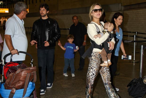 Sorridente, ela embarca com o marido - de casaco de couro -, o filho Davi, de camiseta azul, e o caçula (Foto: Manuela Scarpa / Foto Rio News)