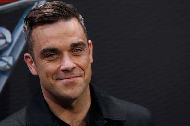 Após encostar em fãs, Robbie Williams faz cara de nojo e lava as mãos