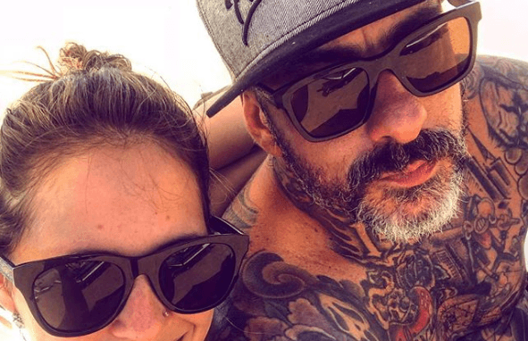 Chef Henrique Fogaça aparece ao lado da mulher sem camisa e exibe corpo todo tatuado