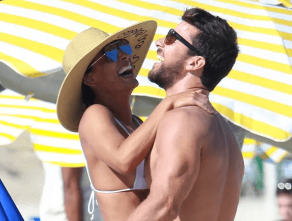 Juliana Paes curte praia com a família e troca beijos com o marido