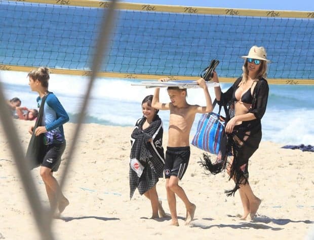 No Brasil, Fernanda Lima vai à praia com filhos gêmeos e corpo impressiona