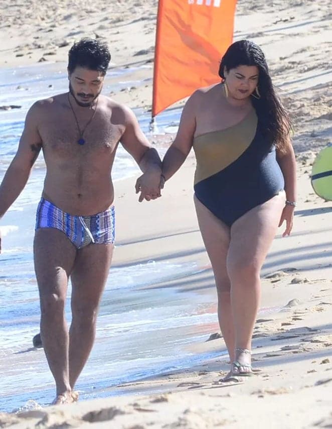 Fabiana Karla passeia na praia de mãos dadas com o namorado
