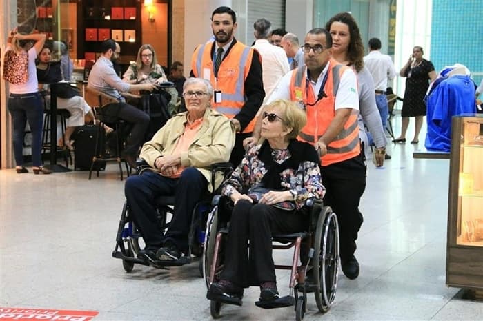 Tarcísio Meira e Gloria Menezes embarcam de cadeira de rodas no aeroporto Santos Dumont no Rio (Foto: Audrey Assed/AgNews)