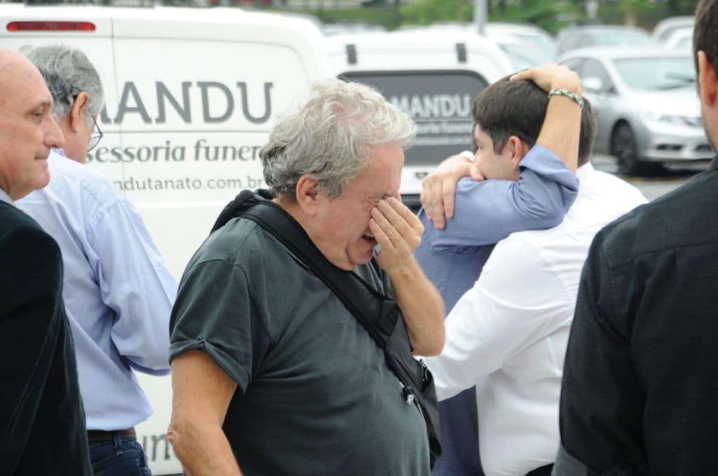 Irmão de Gugu Liberato passa mal no enterro do apresentador e precisa ser amparado