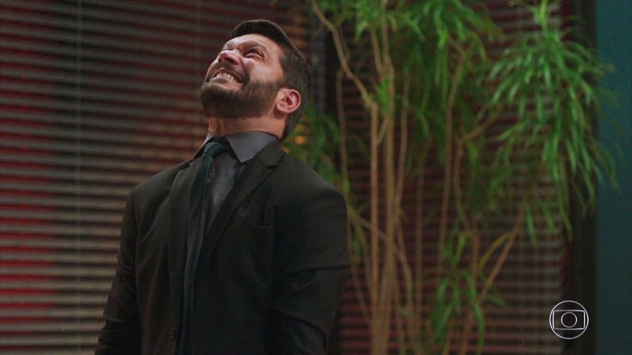 Ator Armando Babaioff como Diogo na novela Bom Sucesso está em um escritório com itens de madeira, planta alta ao fundo e vestido de terno e gravata negros está enfurecido Ator Armando Babaioff como Diogo na novela Bom Sucesso está em um escritório com itens de madeira, planta alta ao fundo e vestido de terno e gravata negros está enfurecido