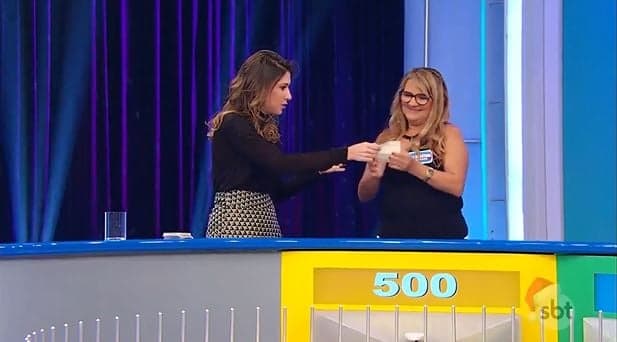 Rebeca Abravanel se assusta com atitude de participante e arranca papel suspeito de sua mão no palco