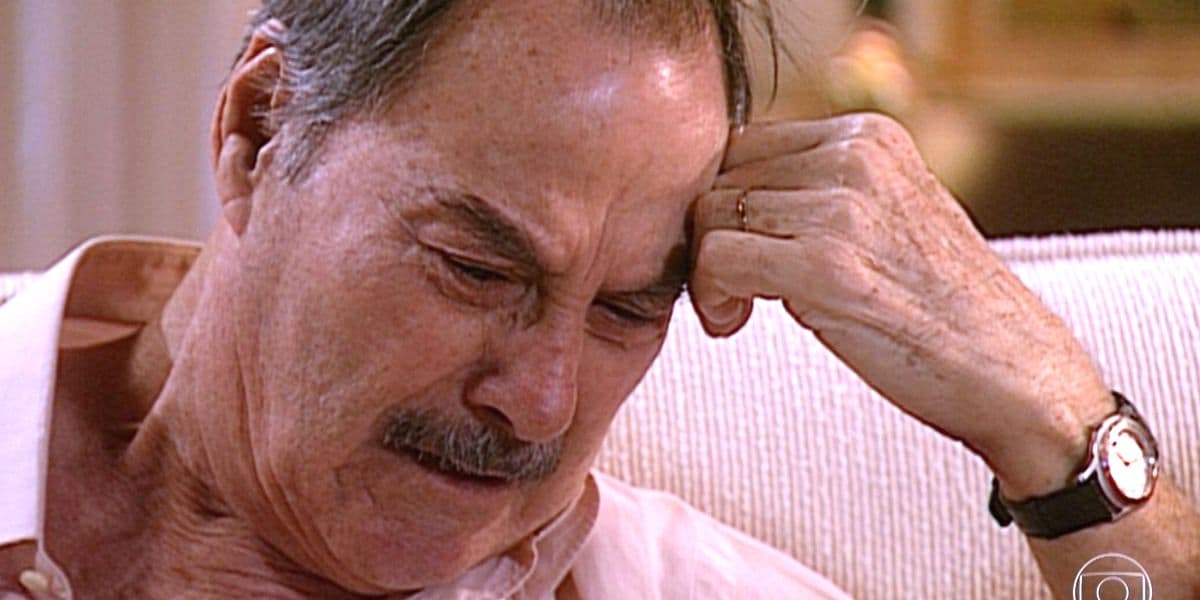 Paschoal, homem velho, branco e bigode, chora com mão encostada na sua testa em Laços de Família Paschoal, homem velho, branco e bigode, chora com mão encostada na sua testa em Laços de Família