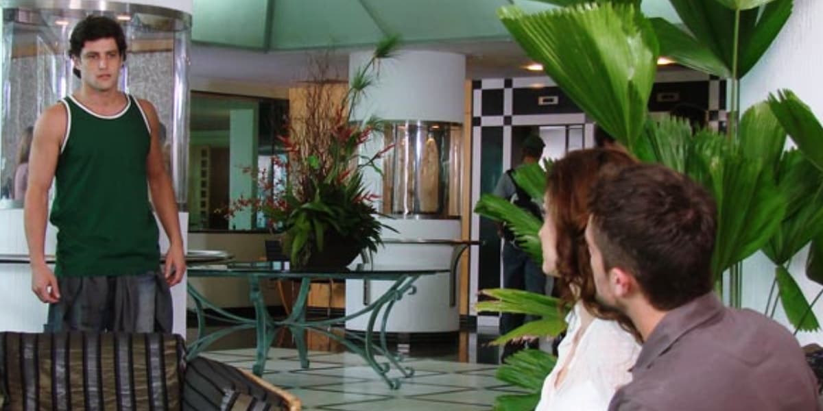 em recepção de hotel na novela ti-ti-ti armandinho vestido de verde flagra desirée e jorgito sentados em sofá