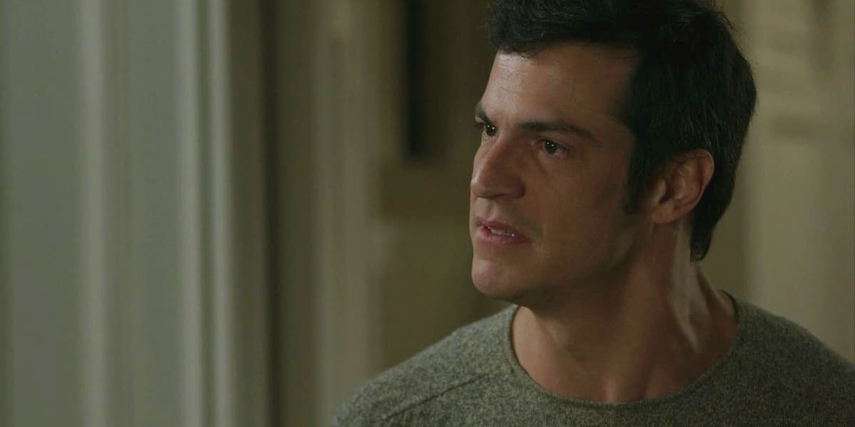Eric usa camisa cinza e cabelo liso preto em cena de Pega Pega Eric usa camisa cinza e cabelo liso preto em cena de Pega Pega