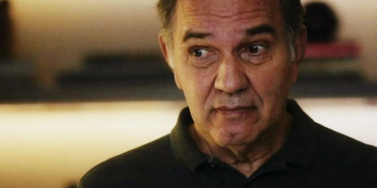 Guerra em cena da novela Travessia usando uma camisa azul escura Guerra em cena da novela Travessia usando uma camisa azul escura