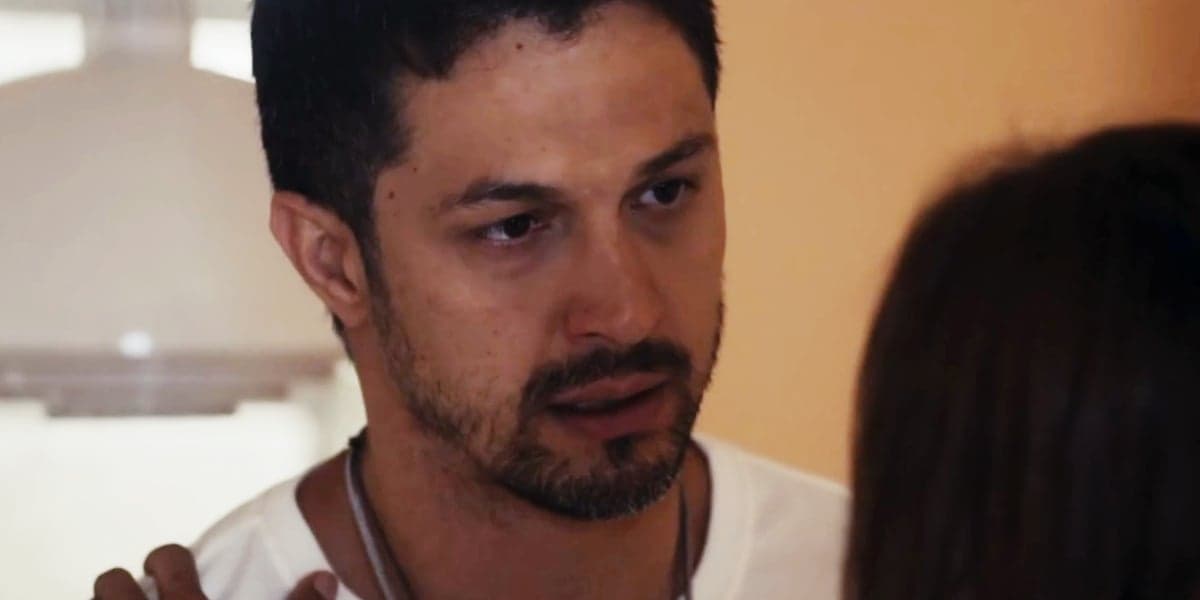 Oto usa camisa branca e colares prata em cena da novela Travessia