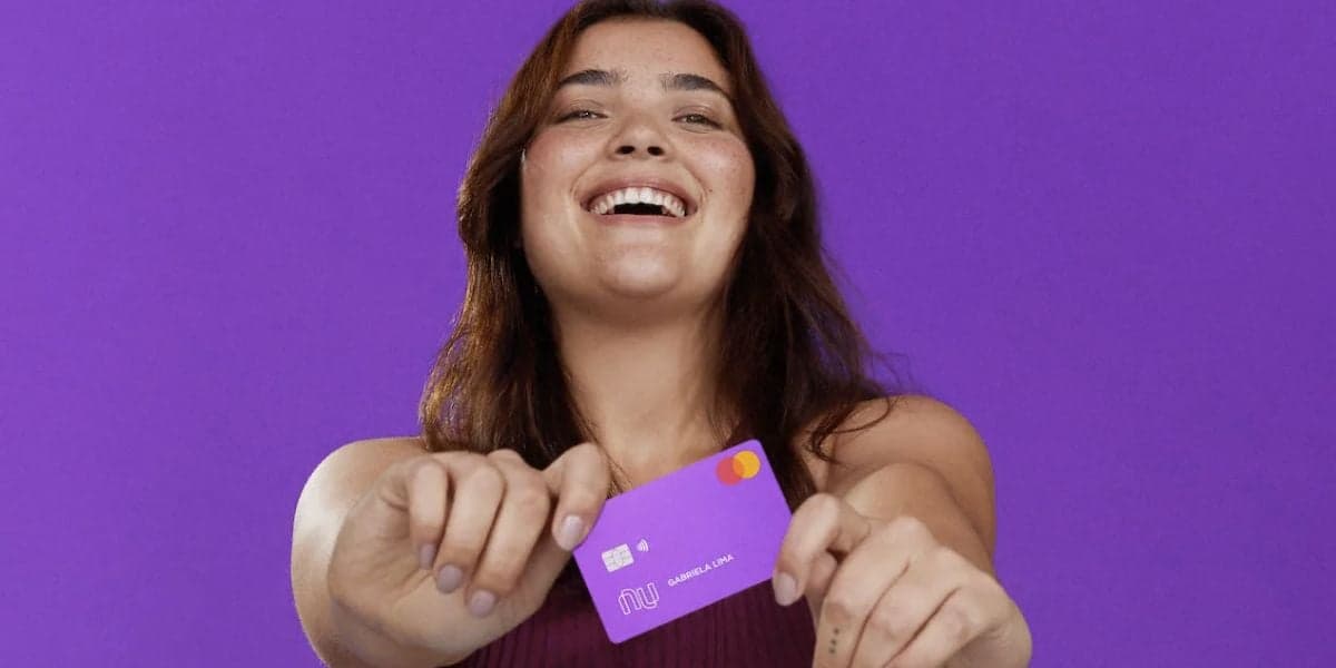 Pessoa feliz segurando cartão do Nubank (Foto: Reprodução / Internet)