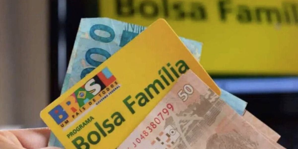 Pessoa segurando cartão do Bolsa Família e notas (Foto: Reprodução / Internet) 