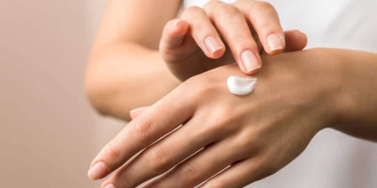 Passar creme nas mãos e unhas (Reprodução: Canva)