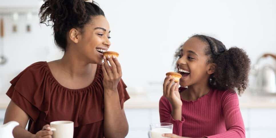 Mãe e filha comendo biscoitos (Foto: Canva) 