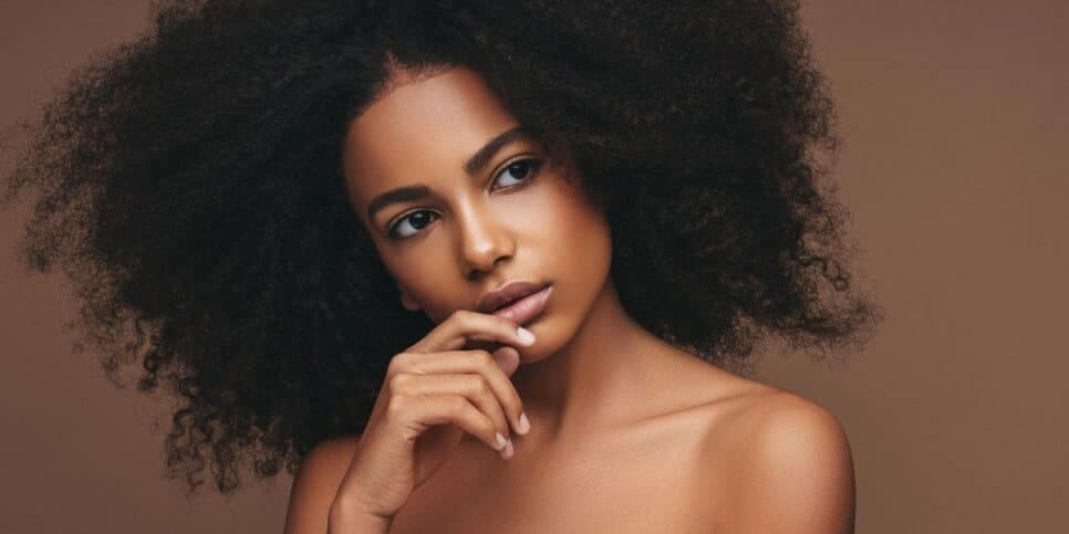 Mulher com o cabelo cacheado (Foto: Canva)