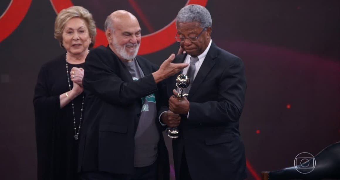 O ator Milton Gonçalves recebendo o Troféu Mário Lago ao lado de colegas da Globo (Foto: Reprodução) O ator Milton Gonçalves recebendo o Troféu Mário Lago ao lado de colegas da Globo (Foto: Reprodução)