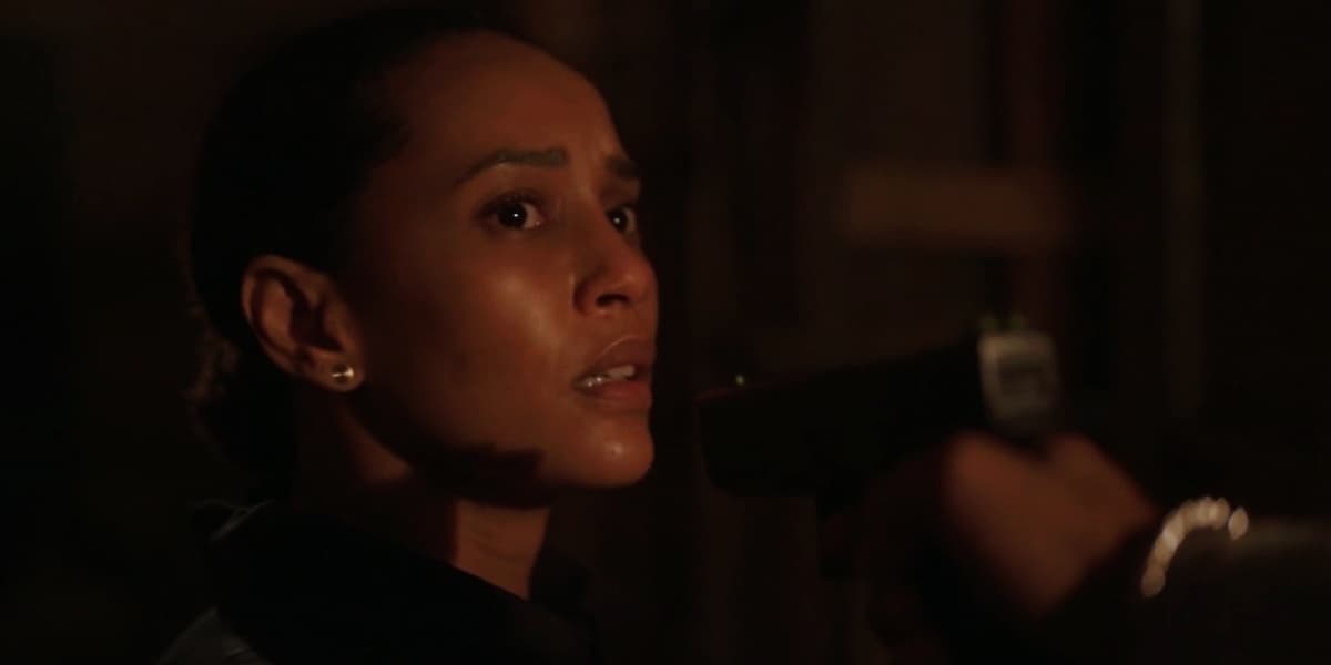Vitória de Amor de Mãe, está em cena escura da novela com arma apontada para o seu rosto, ela é uma mulher negra que tem expressão de apreensão Vitória de Amor de Mãe, está em cena escura da novela com arma apontada para o seu rosto, ela é uma mulher negra que tem expressão de apreensão