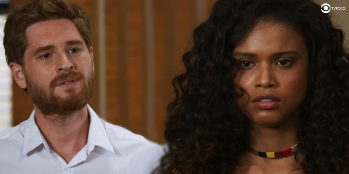 cena da novela salve-se quem puder com úrsula, mulher negra usando blusa laranja e gael, homem vestindo camisa branca e de cabelos curtos ruivos cena da novela salve-se quem puder com úrsula, mulher negra usando blusa laranja e gael, homem vestindo camisa branca e de cabelos curtos ruivos