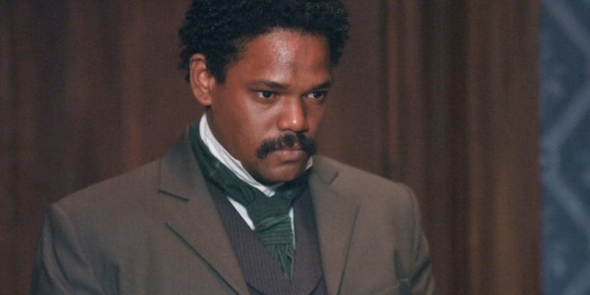 Samuel, homem negro está com terno marrom, camisa branca, de cabeça abaixada na novela Nos Tempos do Imperador Samuel, homem negro está com terno marrom, camisa branca, de cabeça abaixada na novela Nos Tempos do Imperador