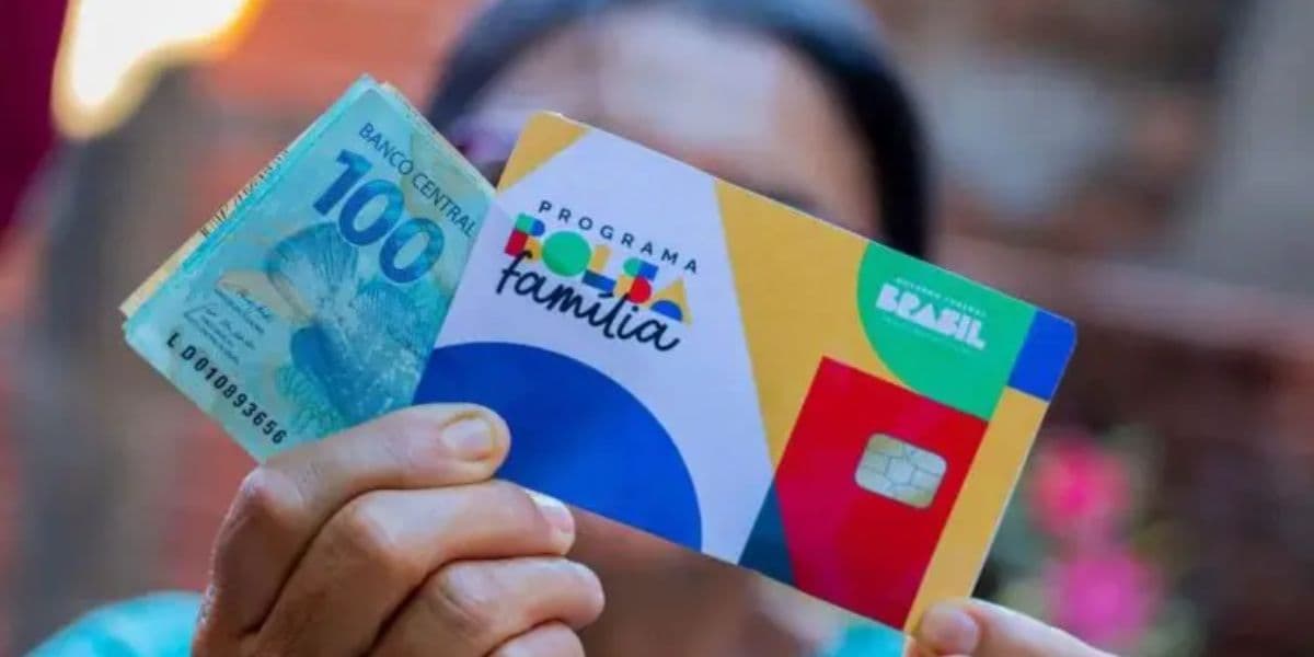 Mulher recebendo o pagamento do Bolsa Família com o dinheiro em mãos e o cartão do programa social - Foto Reprodução Internet Mulher recebendo o pagamento do Bolsa Família com o dinheiro em mãos e o cartão do programa social - Foto Reprodução Internet