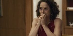 Núbia está sentada com as mãos apegada a terço na novela Travessia Núbia está sentada com as mãos apegada a terço na novela Travessia