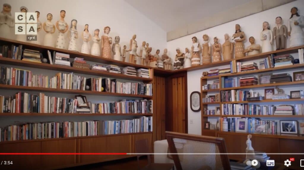 Sala com coleção exotica e estantes com livros da mansão de Marieta Severo no Rio de Janeiro (Foto: Reprodução/YouTube Casa GNT) Sala com coleção exotica e estantes com livros da mansão de Marieta Severo no Rio de Janeiro (Foto: Reprodução/YouTube Casa GNT)