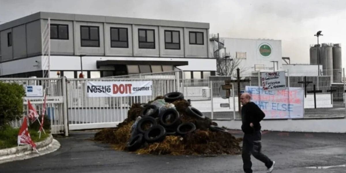 Pedestre passa diante da fábrica das pizzas Buitoni em que funcionários queimaram pneus como forma de protesto contra seu fechamento (Foto: Reprodução / François Lo Presti) Pedestre passa diante da fábrica das pizzas Buitoni em que funcionários queimaram pneus como forma de protesto contra seu fechamento (Foto: Reprodução / François Lo Presti)